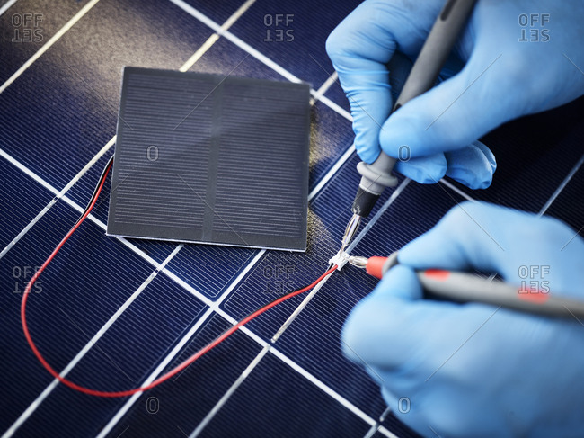 Technician measuring resistor of silicon solar cell