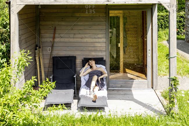 Woman relaxing on a lounge outside sauna