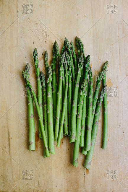 Bunch of fresh cut garden asparagus on a wooden cutting board