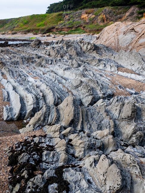 Layers of weathered stone on coastal beach
