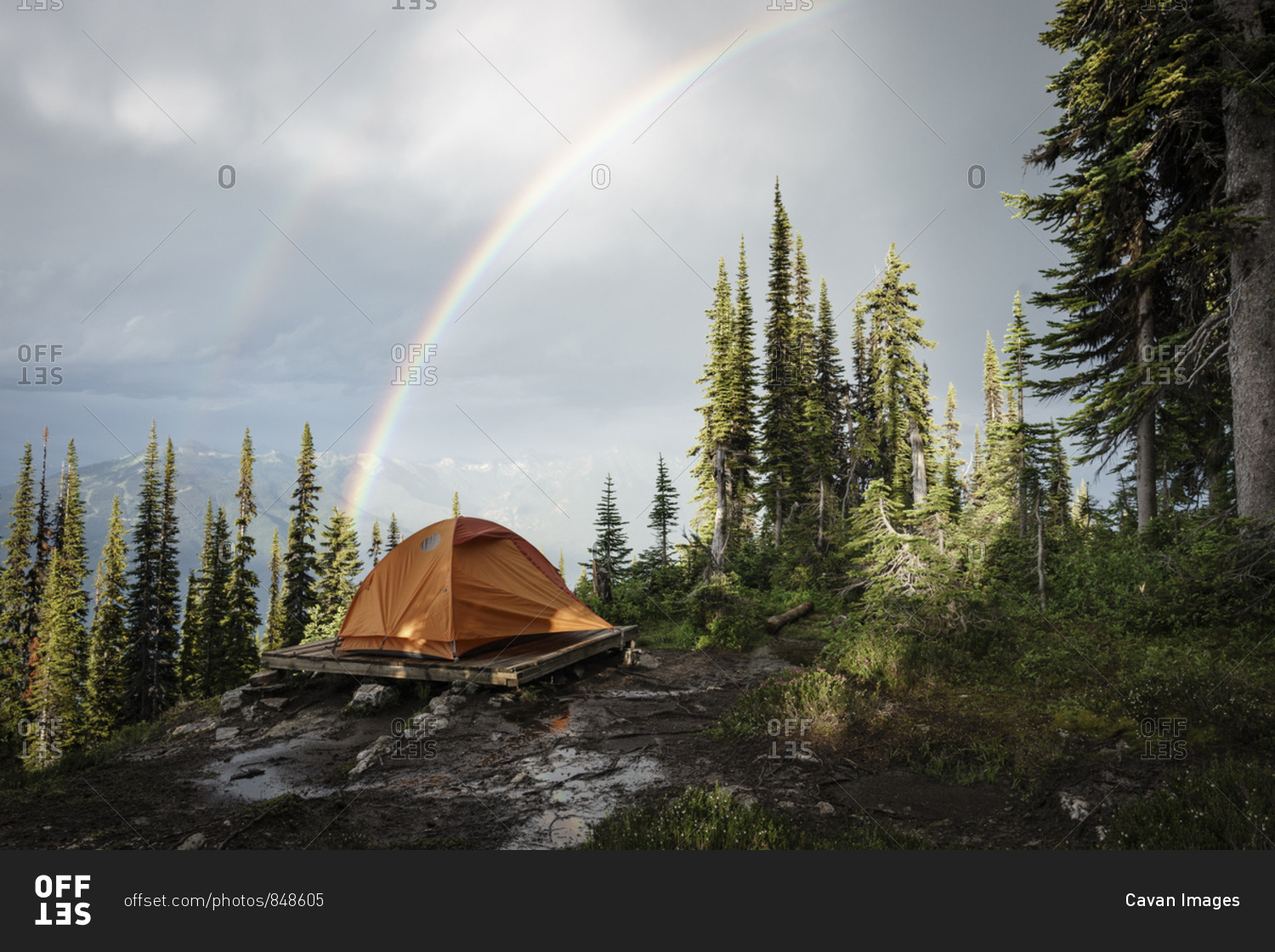 Camping tent in mountain forest with rainbow, British Columbia, Canada