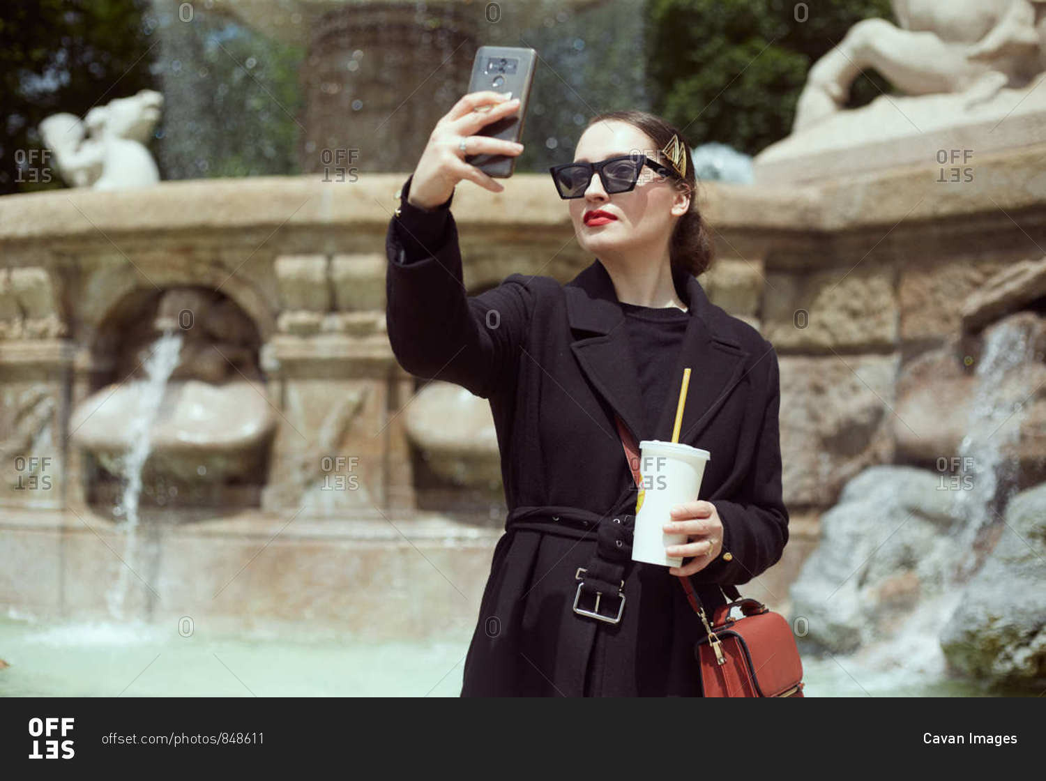 Young woman taking selfie by the fountain