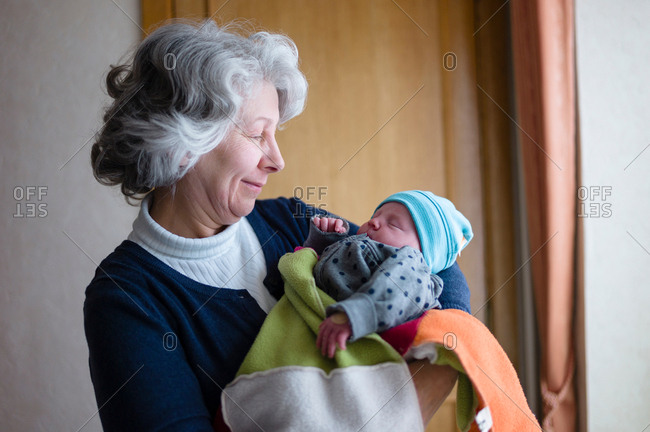 Grandmother holds her newly born granddaughter in her arms