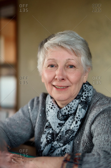 a mature woman sitting at a table at a family dinner smiling