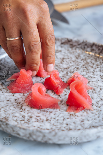 Chef preparing tuna fish appetizer on a speckled plate