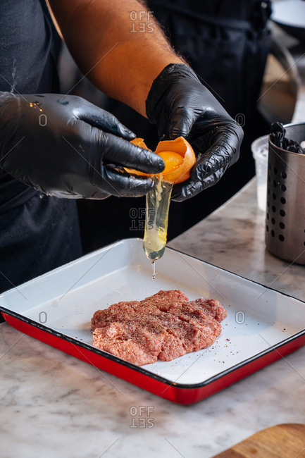 Chef preparing meat for meatballs with egg