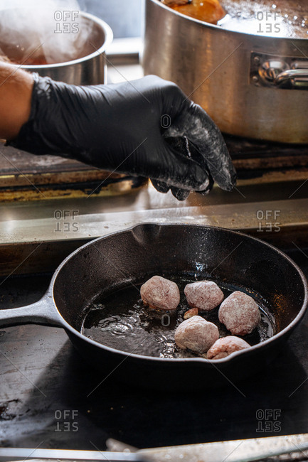 Chef preparing meat in a skillet