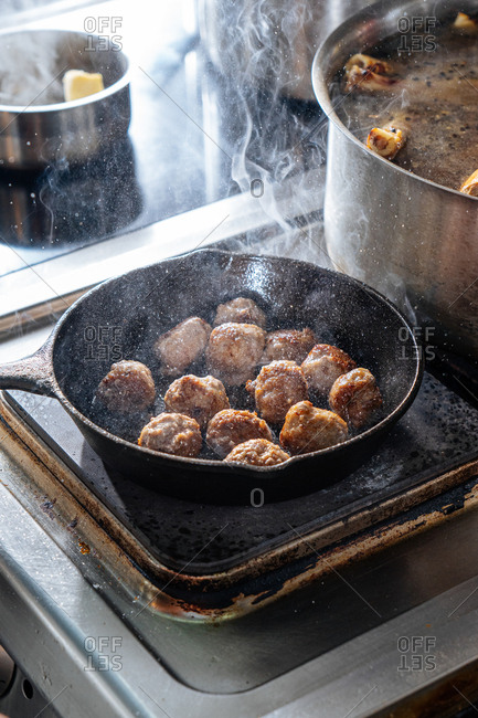 Meatballs browning in a skillet