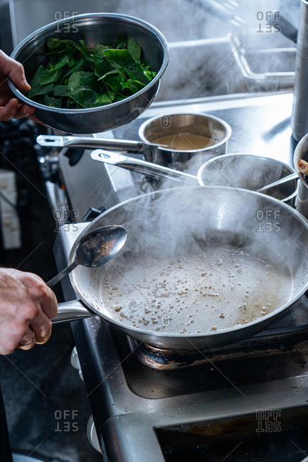 Chef preparing pan for cooking spinach