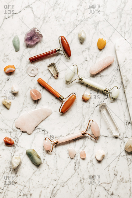 From above photo of crystal face massagers composition on marble table.