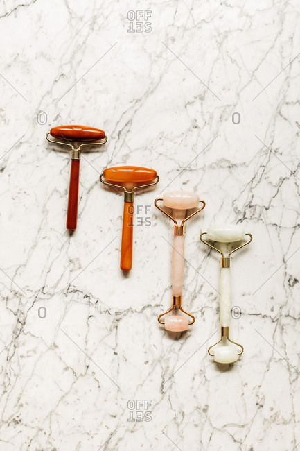 From above photo of crystal face massagers composition on marble table.