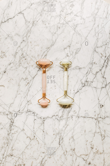 From above photo of crystal face massagers composition on marble table.