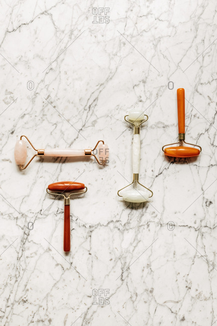 From above photo of crystal face massagers composition on marble table.