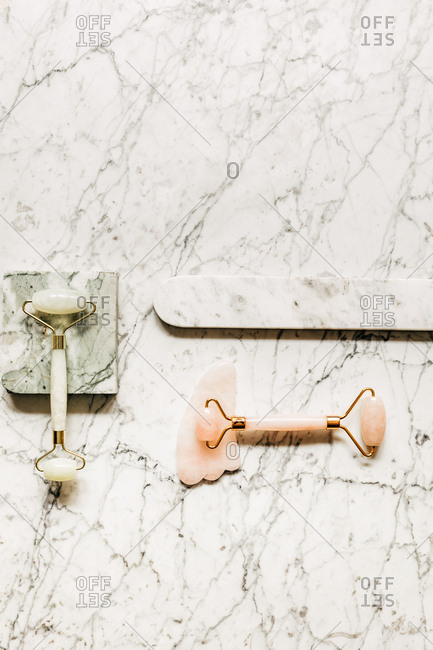 From above photo of crystal face massagers composition on marble table.