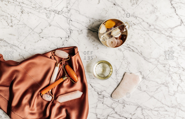 From above photo of composition with face massage therapy cristals on marble table.