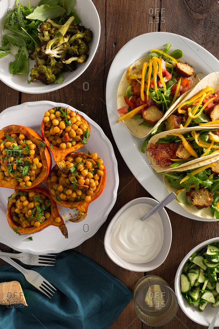 Autumn dinner table with baked pumpkin with chickpeas curry, tortilla with falafel and salad