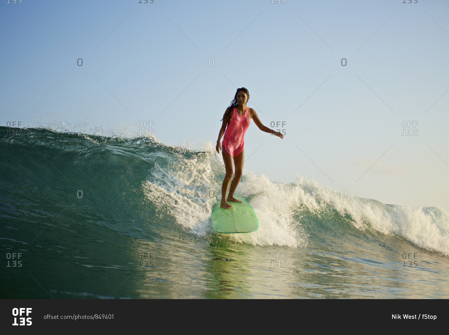 Female surfer riding ocean wave stock photo - OFFSET