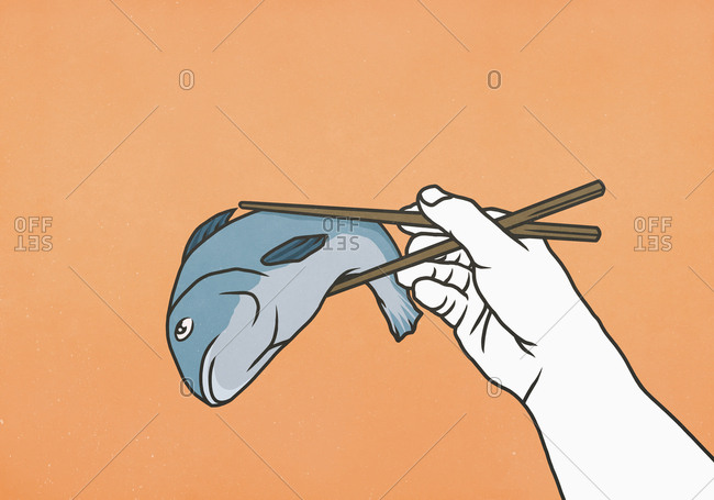 Chopsticks holding whole dead fish