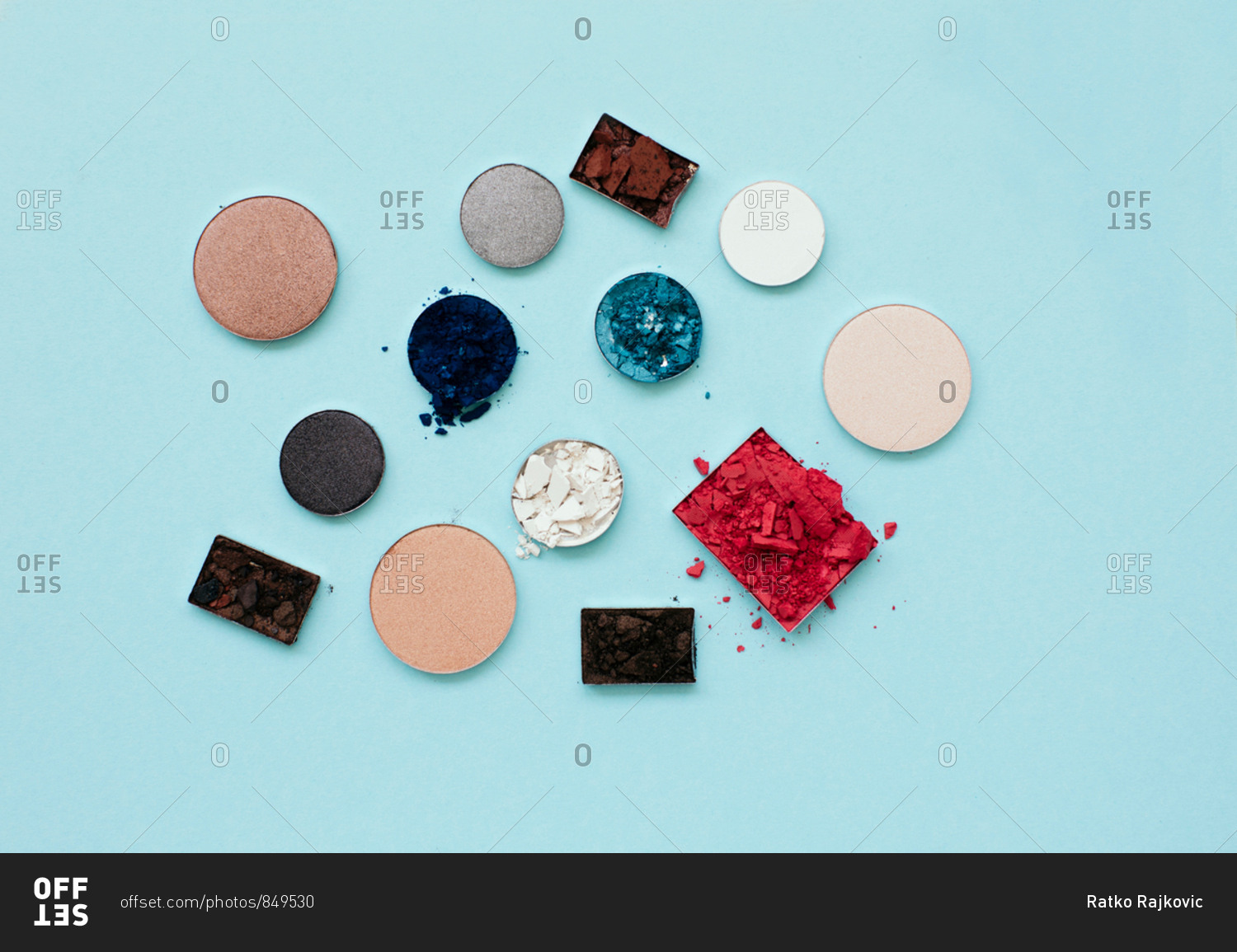 Flatlay of pressed powder makeup on a pale blue background