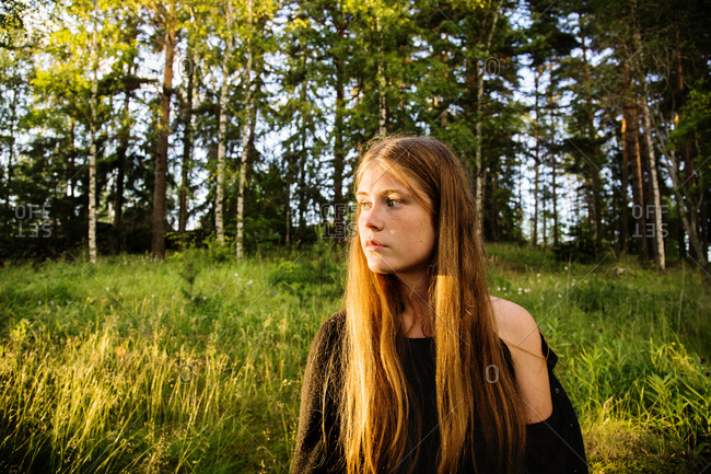 Portrait of young woman in forest at sunset