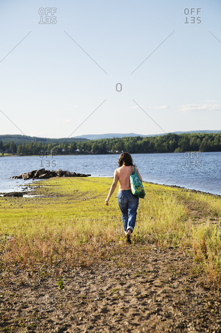 Woman walking by lake - Offset