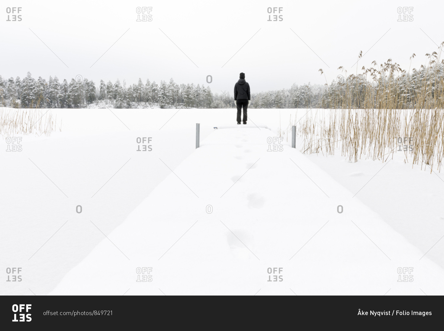 Mature woman standing next to frozen lake in Ostergotland,  Sweden