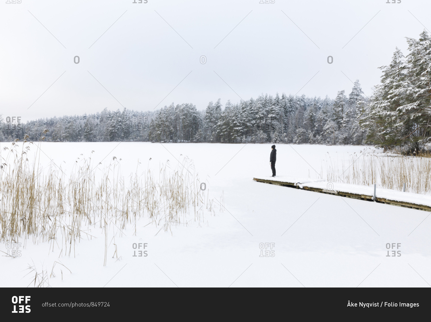 Mature woman standing over frozen lake in Ostergotland,  Sweden