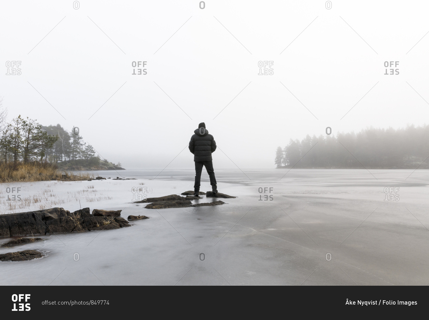 Man on rocks in frozen lake in Lotorp,  Sweden
