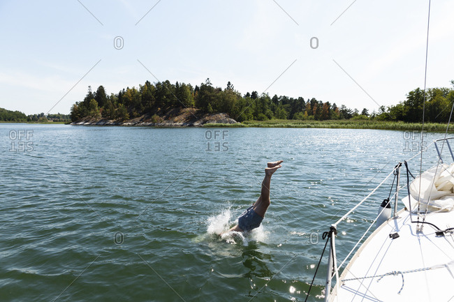 Man diving into sea off yacht