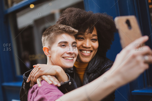 Young adult lesbian couple taking selfie in London
