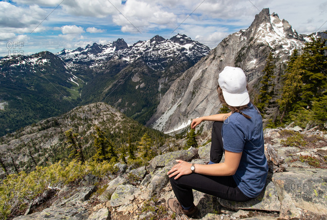 Young hiker girl gazes at distant mountains in Alpine Lakes Wilderness