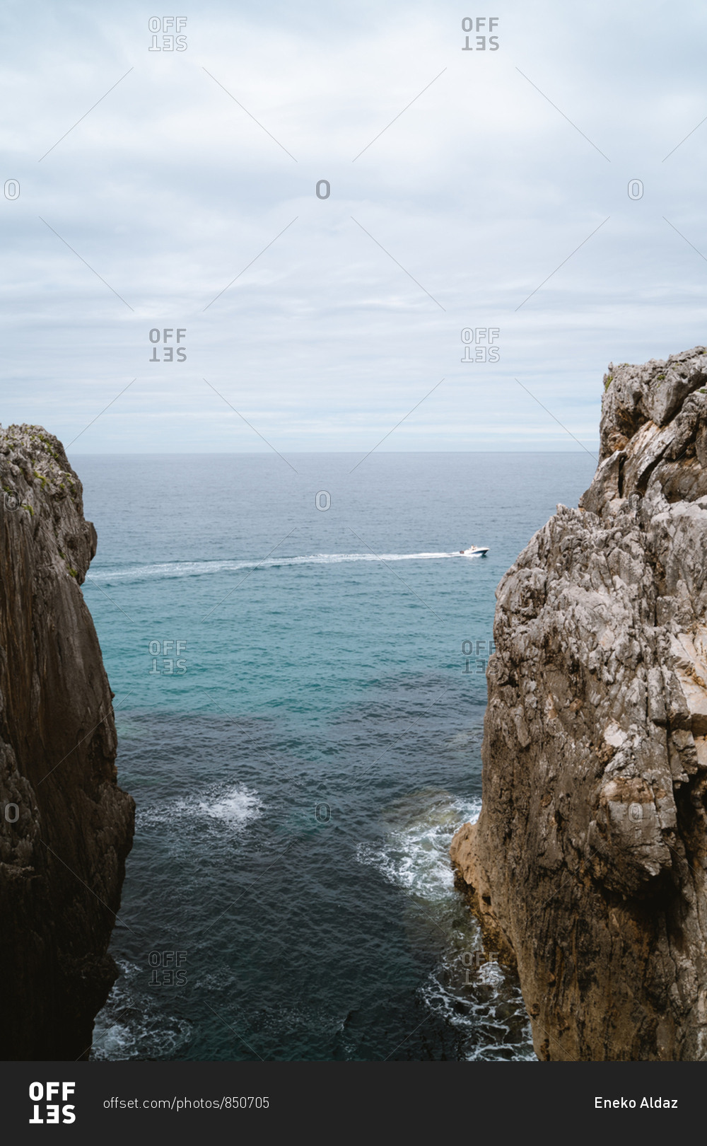 Small boat passing between two cliffs