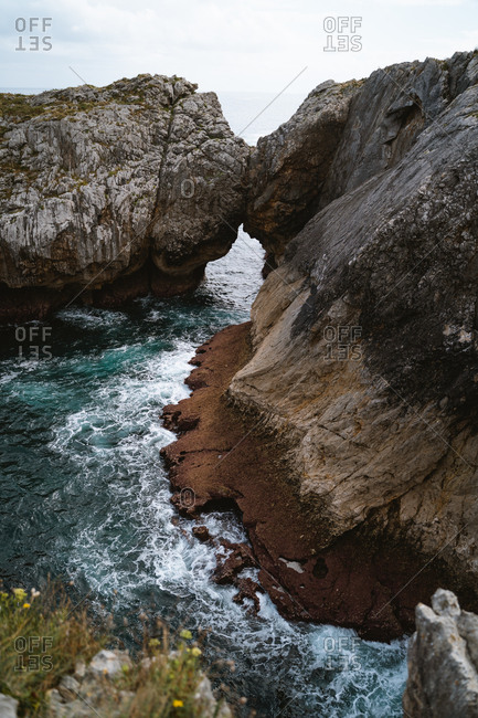 Stone arch and wrinkled textures eroded by the ocean in Asturias