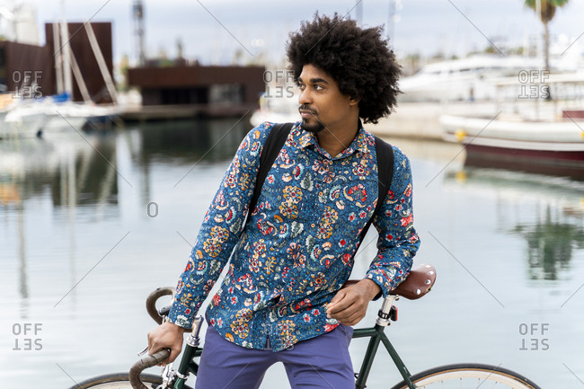 Stylish man with bicycle at the marina