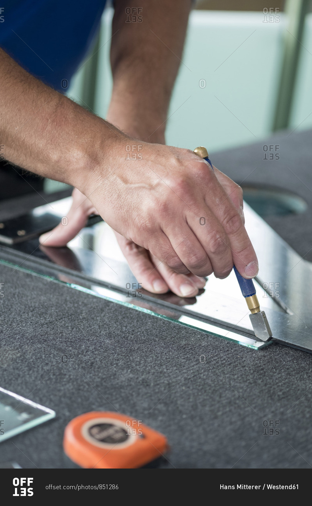 Glazing glazier during work cutting glass with glass cutter stock