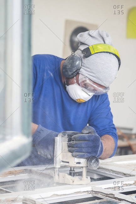 Glazier sanding window pane