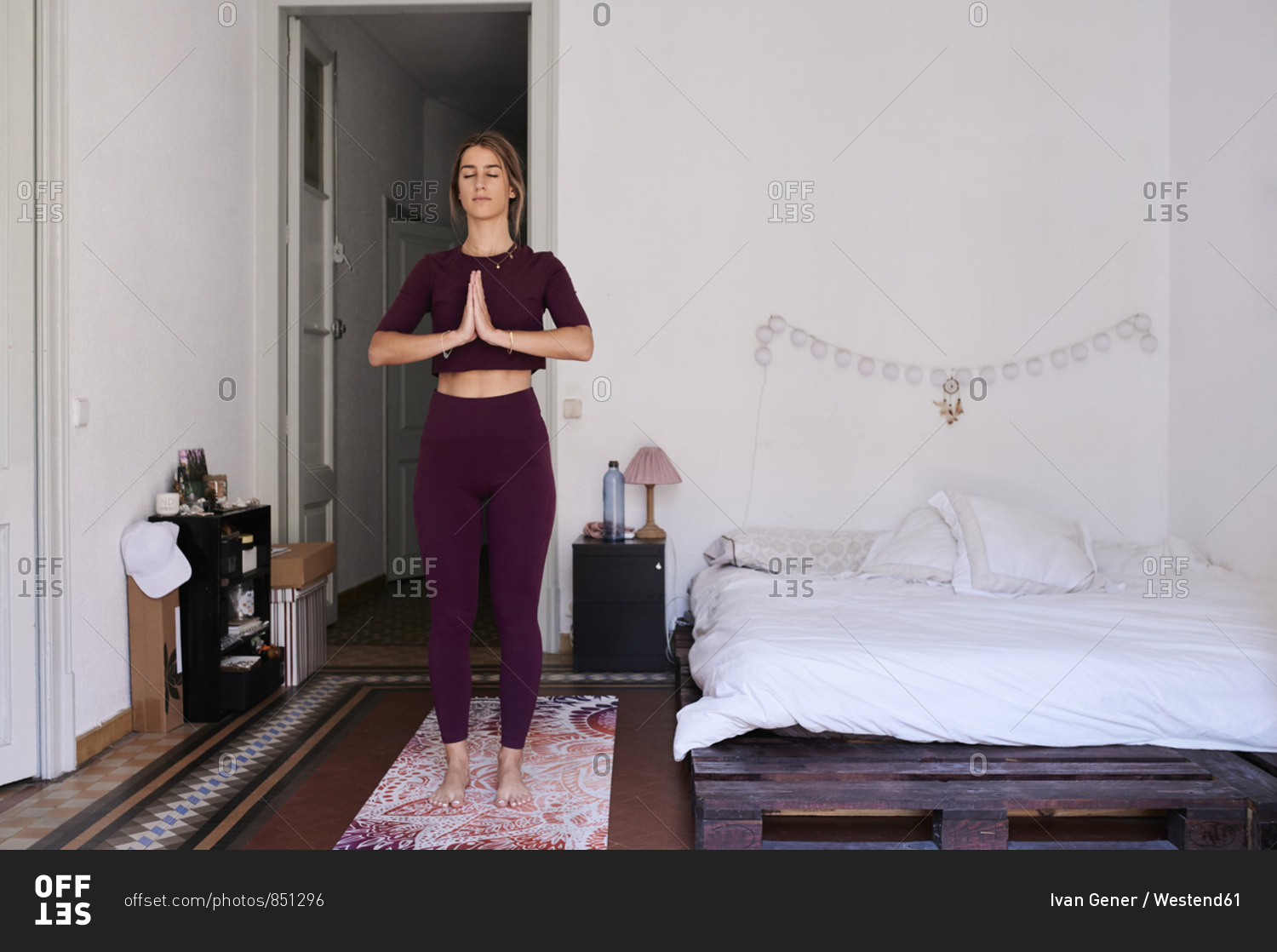 Young brunette woman practicing yoga in student dorm