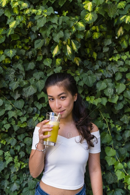 Portrait of smiling young woman drinking a healthy drink