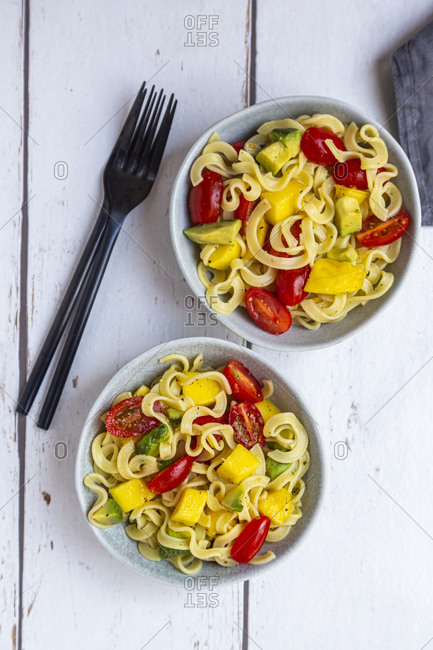 Two bowls of pasta salad with mango- avocado and cherry tomatoes