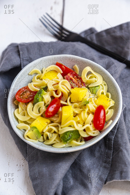 Bowl of pasta salad with mango- avocado and cherry tomatoes