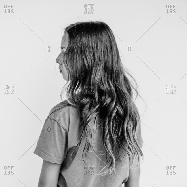 Rear view portrait of young girl with long wavy hair
