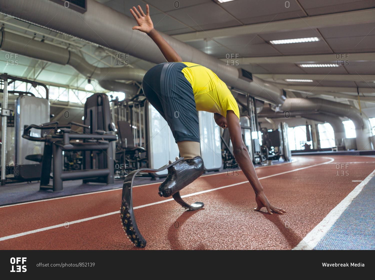 Disabled African American male athletic running on sports track in fitness center