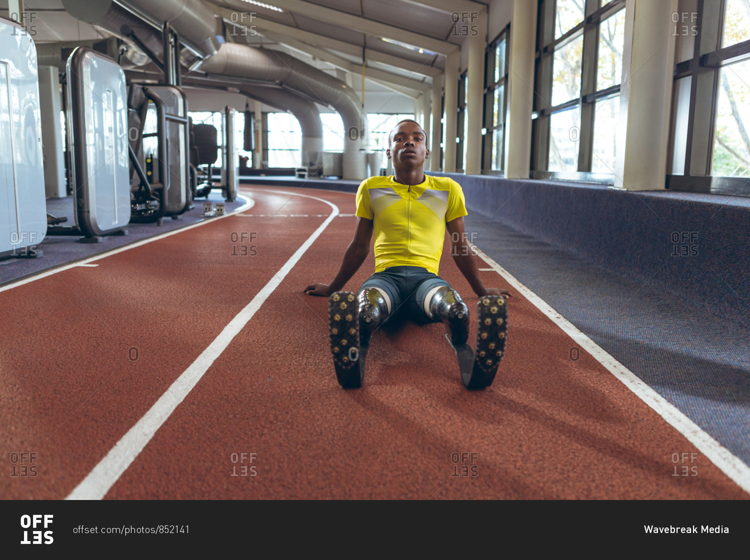 Disabled  African American male athletic relaxing on a running track in fitness center