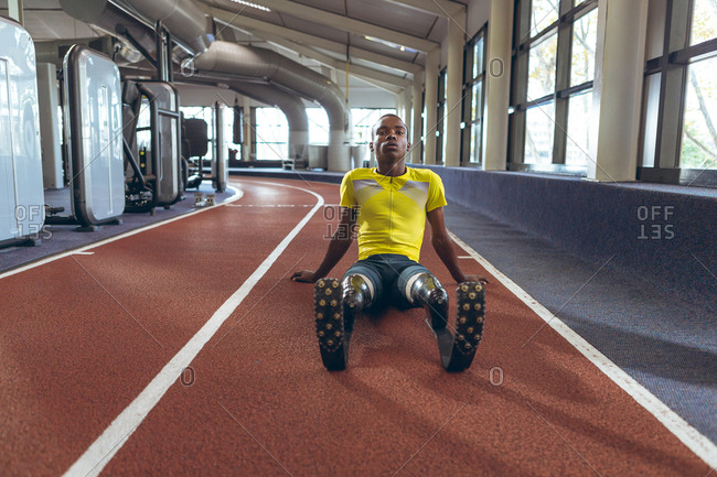 Disabled  African American male athletic relaxing on a running track in fitness center