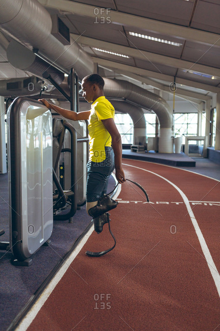 Disabled African American male athletic standing on running track in fitness center