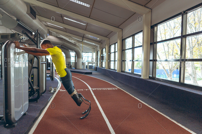 Disabled African American male athletic exercising on running track in fitness center