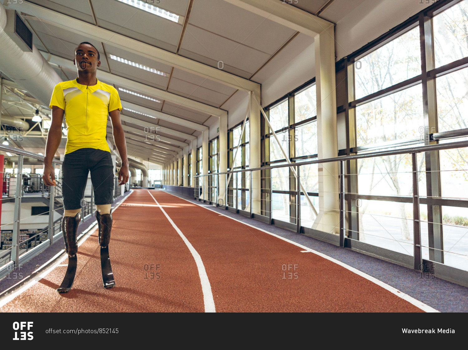 Disabled African American male athletic standing on running track in fitness center
