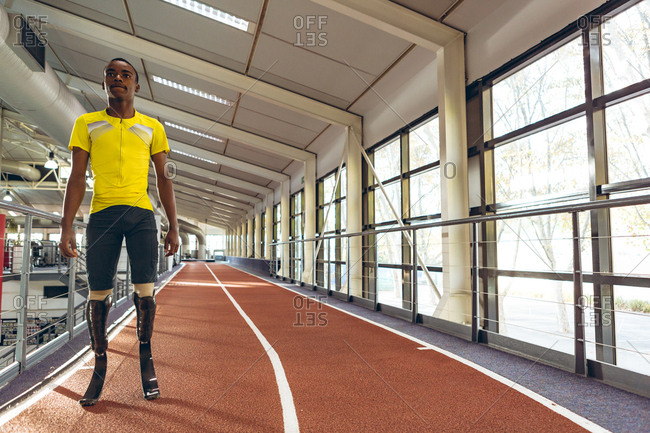 Disabled African American male athletic standing on running track in fitness center