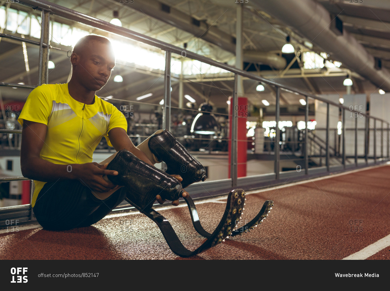 Disabled African American male athletic sitting on race track in fitness center