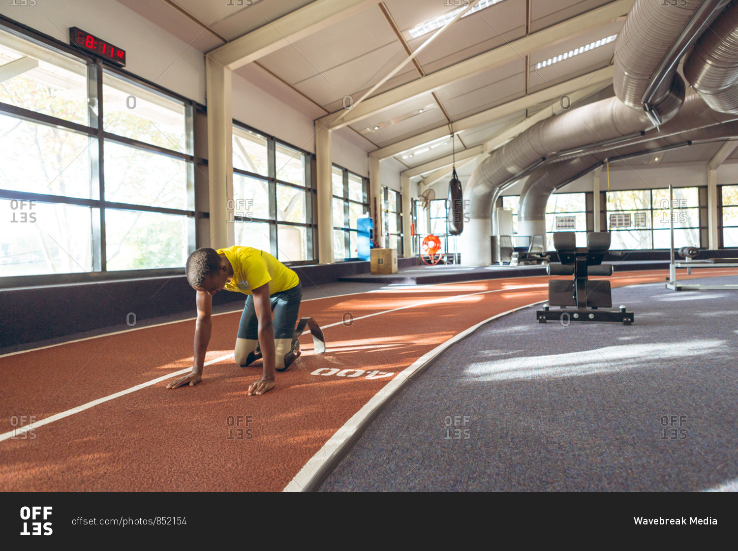 Disabled African American male relaxing on a running track in fitness center
